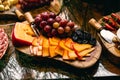Edamer type sliced Ã¢â¬â¹Ã¢â¬â¹Dutch cheese with sour grapes and raisins, holiday food, rustic decorated table
